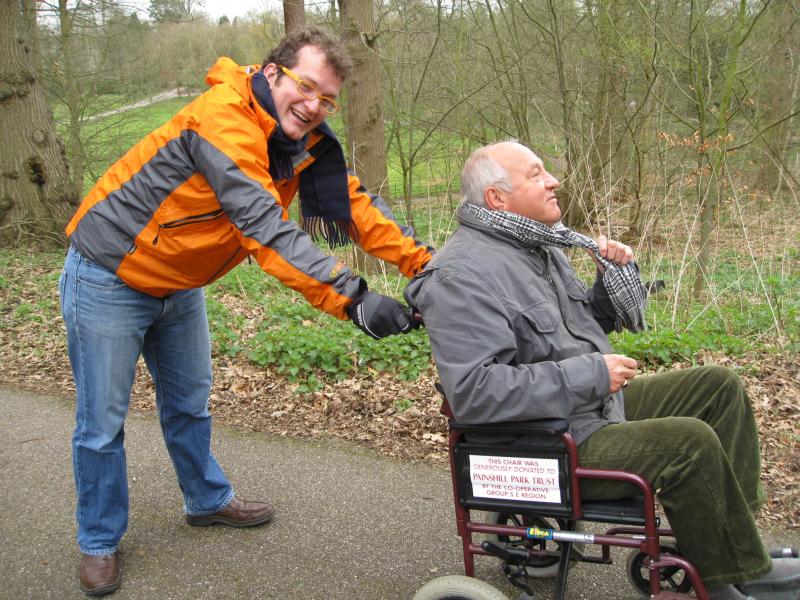 Carer pushing man in wheelchair - both looking happy!