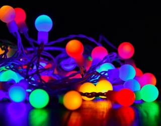 Coloured circular string lights on floor with black background