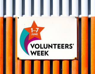 Volunteers' Week sign on white and orange metal background