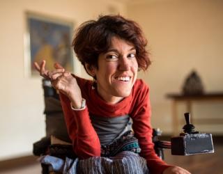 Woman with visible disability raising right hand 