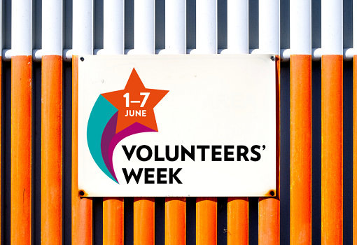 Volunteers' Week sign on white and orange metal background
