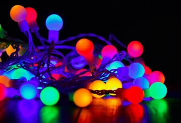 Coloured circular string lights on floor with black background