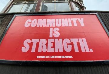Community is strength word-based poster on fence 