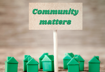 Green plastic houses with signpost reading 'Community matters'