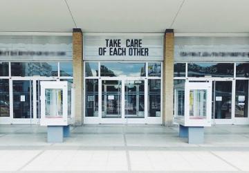 Take Care of Each Other text sign on building