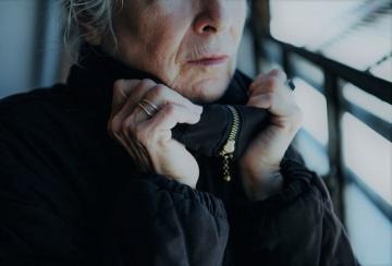 Senior woman in winter coat indoors
